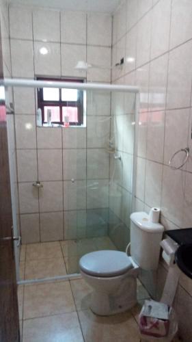 a bathroom with a toilet and a glass shower at Mongaguá, AGENOR de Campos, PRAIA in Mongaguá