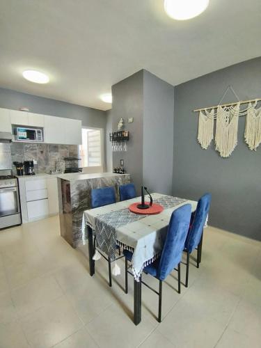 a kitchen with a table and some blue chairs at Estancia rivera Cancún in Cancún