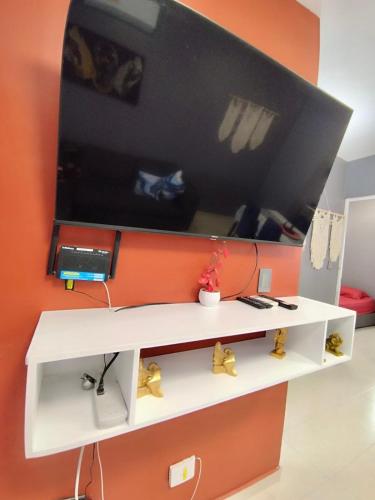 a white shelf with a tv on a wall at Estancia rivera Cancún in Cancún