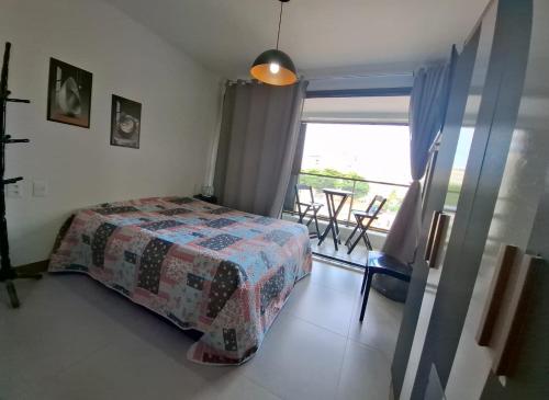 a bedroom with a bed and a view of a balcony at ZN Studio Barra in Salvador