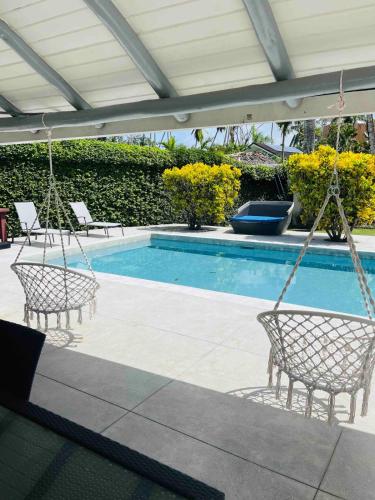 a swimming pool with two chairs and a swing at Villa Pierretta in the center, Playa Las Terrenas in Las Terrenas