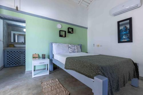 a bedroom with a bed with a green wall at Villa Pierretta in the center, Playa Las Terrenas in Las Terrenas