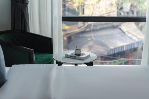 a table with a cup on it next to a window at 22Land Cloud Hotel in Hanoi