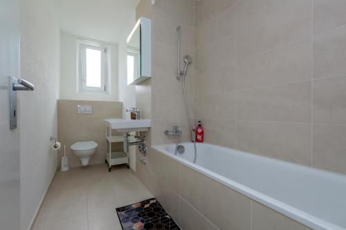 a bathroom with a tub and a sink and a toilet at KAYA Zurich Apartment 3B - Downtown 2BR Deluxe Apt in Zürich