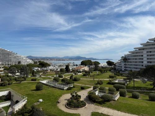 - une vue sur un parc avec des bâtiments et des arbres dans l'établissement Appartement Vue sur la mer à 5 minutes des plages, à Villeneuve-Loubet