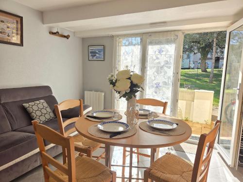 un salon avec une table avec des chaises et un canapé dans l'établissement Confortable duplex avec terrasse, proche plage et commerces - St Brevin l'Océan - FR-1-364-43, à Saint-Brévin-les-Pins