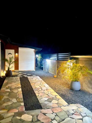 a house with a stone walkway at night at Le Kokon chic in Sainte-Anne