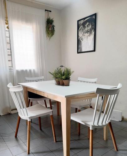 una mesa de comedor con sillas blancas y una planta en Barrio cívico, en Mendoza