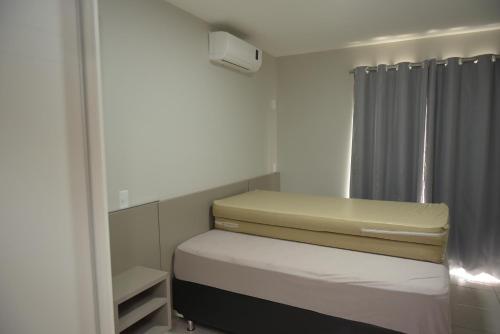 mała sypialnia z łóżkiem i lustrem w obiekcie Enseada Náutico residence w mieście Caldas Novas