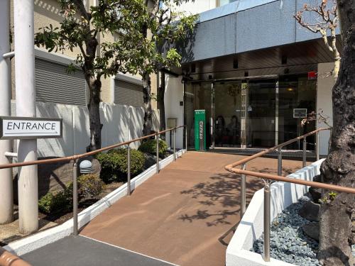 an entrance to a building with a sign that reads entrance at Hotel Cerezo in Tokyo