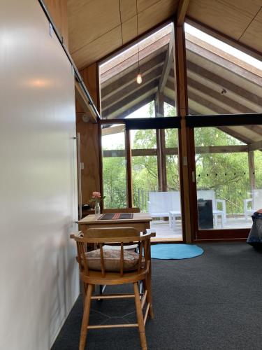 a room with a wooden table and a chair at Treetop Studio in Wellington