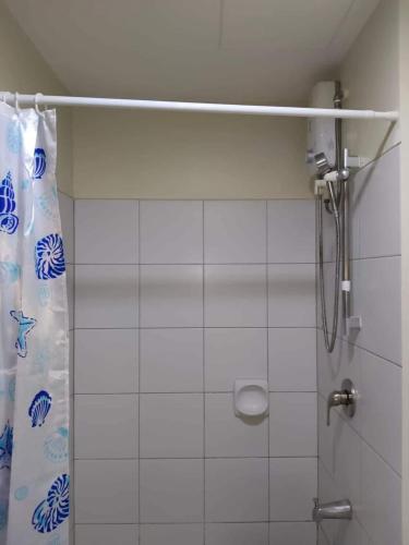a shower in a bathroom with a shower curtain at MaehwensStaycation in Cebu City