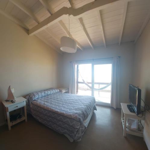 a bedroom with a bed and a large window at Chacras del Mar 4x4 in Mar Azul