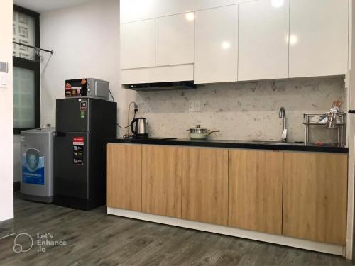 a kitchen with white cabinets and a refrigerator at Gp Apartment View Beach in Da Nang