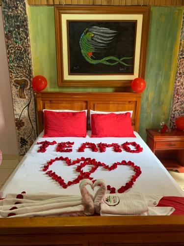 a bed with red roses and hearts on it at Casa Cultural Mindo in Mindo
