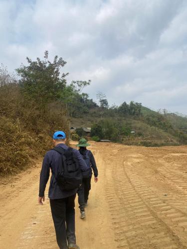 two men are walking down a dirt road at Khách sạn Vườn Quốc gia Ba Bể in Bak Kan