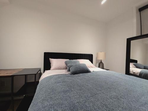 a bedroom with a bed and a table and a mirror at Spacious Bright 9ft Ceiling with Private Entrance in Milton