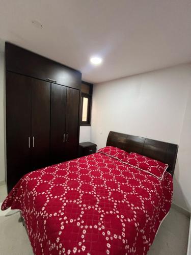 a bedroom with a red bed with a red comforter at Apartamento en Nuevo Apartado 1 in Apartadó