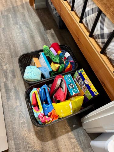 an open suitcase filled with toys on a floor at The Sugar Suite - Renovated with a View! Ski IN-OUT! Heated POOL, Hot tub, sauna, gym, AC, EV in Sugar Mountain