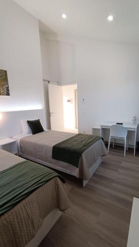 a bedroom with two beds and a table and a desk at CiTY CENTER in Monte