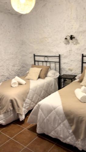 two beds sitting next to each other in a room at Bike Cueva Gorafe in Gorafe