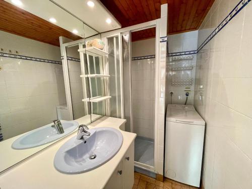 une salle de bain blanche avec un lavabo et une douche dans l'établissement Maison T3 tout confort proche mer, piscine chauffée, tennis - FR-1-231-301, à Bretignolles-sur-Mer
