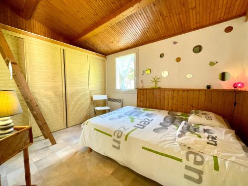 une chambre avec un lit et un plafond en bois dans l'établissement Maison T3 tout confort proche mer, piscine chauffée, tennis - FR-1-231-301, à Bretignolles-sur-Mer