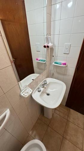 ein Badezimmer mit Waschbecken, Toilette und Spiegel in der Unterkunft Hotel El Torreon in Mendoza