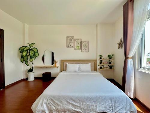 een slaapkamer met een groot wit bed in een kamer bij FLORA HOME DALAT in Da Lat