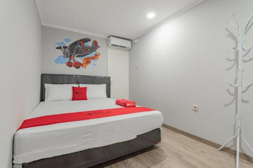 Un dormitorio con una cama grande con almohadas rojas. en RedDoorz Plus near Lembang Park & Zoo, en Bandung