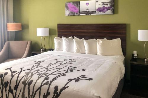 a hotel room with a large bed with a white comforter at Sleep Inn & Suites Quebec City East in Boischâtel
