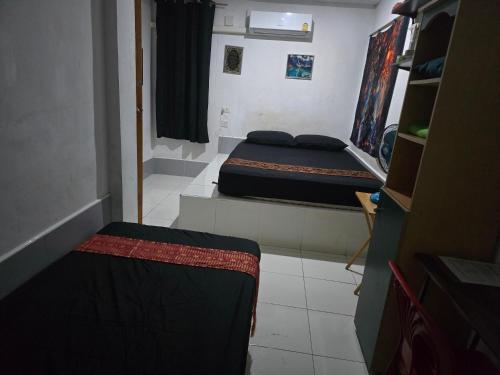 a small room with two beds in it at Jatujak Bangkok guesthouse R8 in Sathani Bang Su