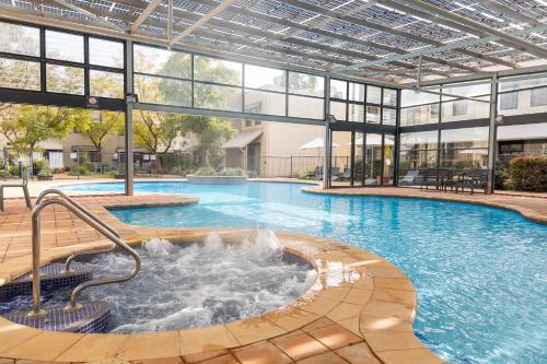 - une grande piscine avec une fontaine dans un bâtiment dans l'établissement Rydges Kalgoorlie, à Kalgoorlie