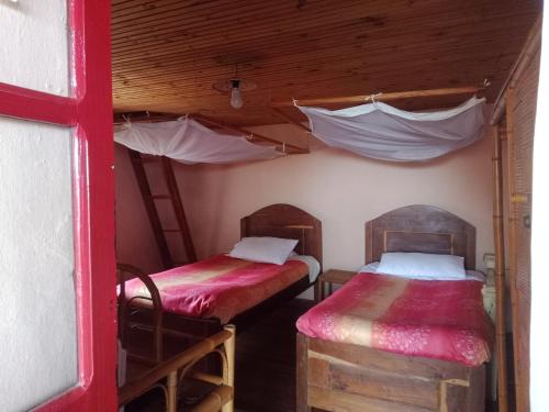 two bunk beds in a room with a red wall at Chez Julienne in Fianarantsoa
