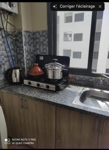 a kitchen counter with a pot on a stove at Laziza in Temara