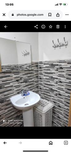 a bathroom with a white sink and a trash can at Laziza in Temara