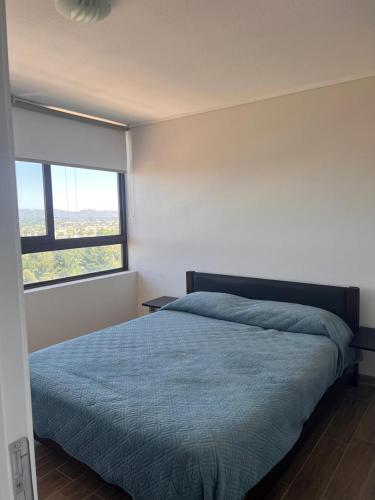 a bedroom with a bed and a large window at Depto equipado - WiFi rápido - 1 min de UCM - piscina rooftop in Talca