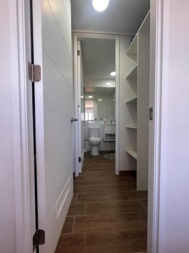 a hallway of a bathroom with a toilet in it at Depto equipado - WiFi rápido - 1 min de UCM - piscina rooftop in Talca
