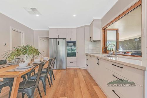 a kitchen with a table and chairs and a refrigerator at The Rad Shack in Echuca