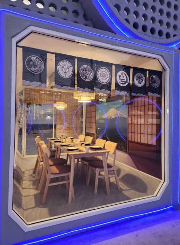 a display window of a restaurant with a table and chairs at Sky dome resotel - โรงแรมสกายโดม รีโซเทล in Bangkok