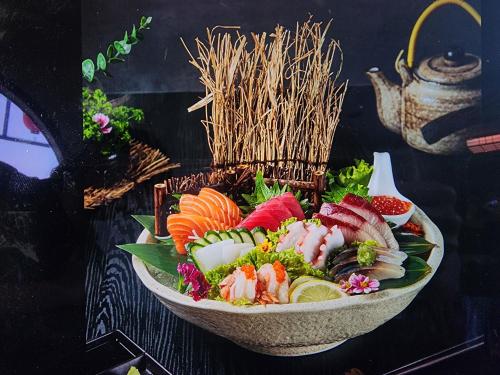 a bowl filled with sushi and vegetables on a table at Sky dome resotel - โรงแรมสกายโดม รีโซเทล in Bangkok