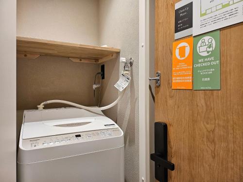 a washing machine sitting next to a door at MKG HOTEL Asakusa in Tokyo