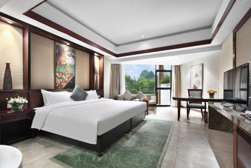 a bedroom with a large bed and a living room at 广悦华阳朔河畔酒店 in Gaotian