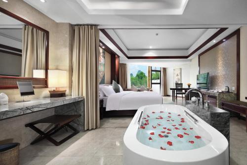 a hotel room with a tub and a bedroom at 广悦华阳朔河畔酒店 in Gaotian