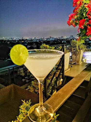 a drink sitting on top of a balcony with a view at Sky dome resotel - โรงแรมสกายโดม รีโซเทล in Bangkok