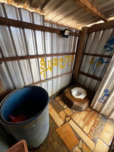 a toilet in a wooden structure with a large barrel at Mondulkiri tour and family homestay in Krong Saen Monourom