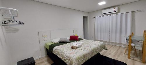 a bedroom with a bed and a table with flowers on it at Suit Confort in Porto Velho