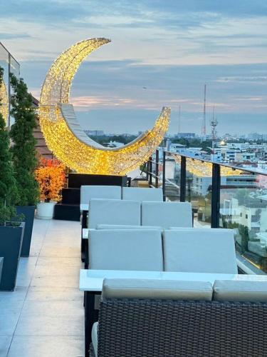 a balcony with white chairs and lights on a building at Sky dome resotel - โรงแรมสกายโดม รีโซเทล in Bangkok