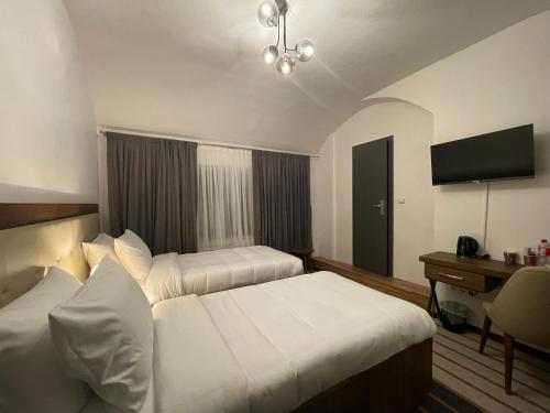 a hotel room with two beds and a desk at Hotel Casa Andalucia in Hallbergmoos
