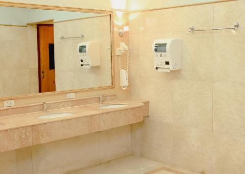 a bathroom with two sinks and a mirror at Richmonde Hotel Ortigas, Manila in Manila